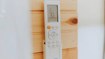 Un thermostat blanc doté d’un écran numérique, de boutons pour sélectionner le mode, régler les paramètres, confirmer et accéder à d’autres fonctions, et portant le nom de la marque « MRCOOL » en bas.