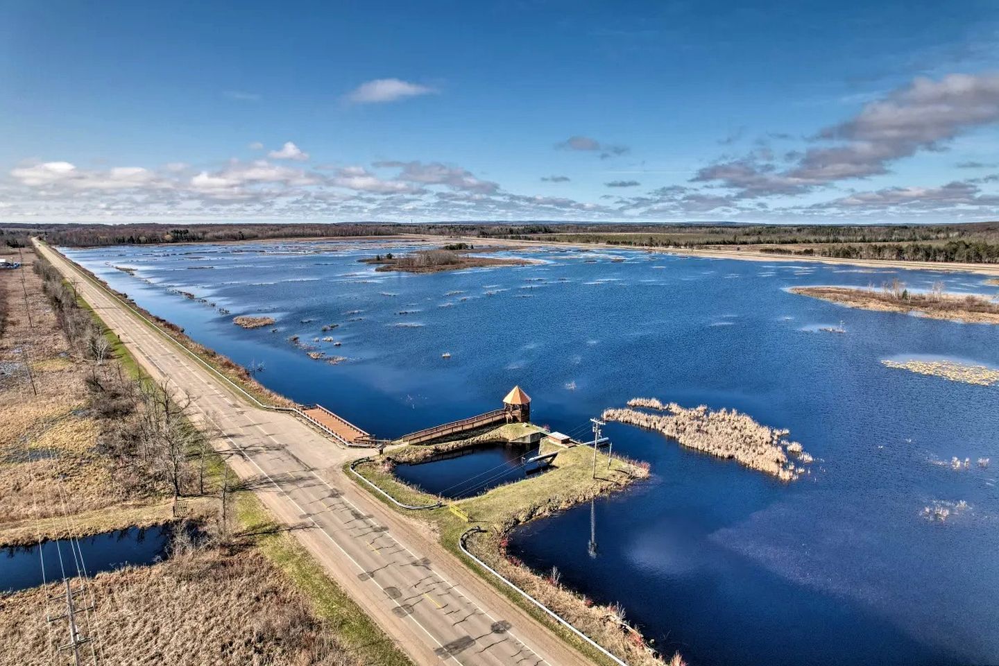 Un río con un puente y una pequeña construcción cerca de la orilla.