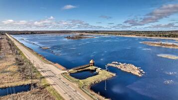 Un río con un puente y una pequeña construcción cerca de la orilla.