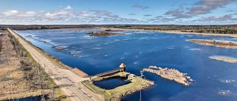 Un río con un puente y una pequeña construcción cerca de la orilla.