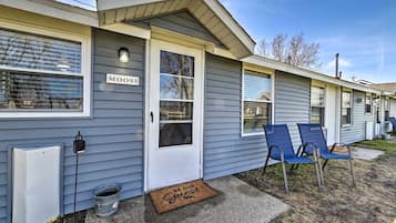 A row of mobile homes with a sign reading 'MOOSE' on the first one, a doormat with 'BE OUR Guests' on the front door, and two blue chairs outside.