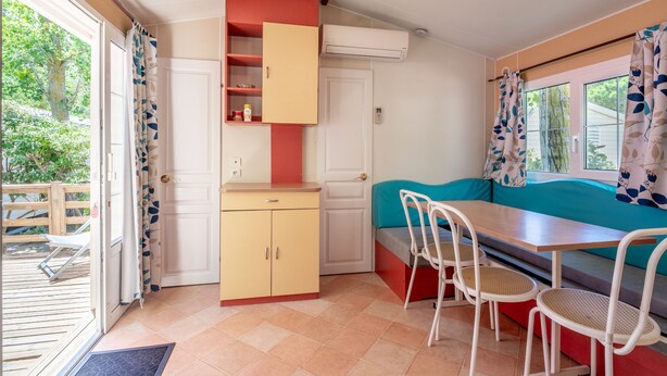 Cocina compacta con comedor, aire acondicionado integrado y vistas al exterior.