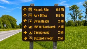 A directional sign with various destinations and distances.