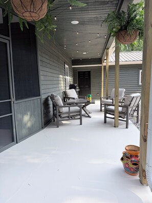 An outdoor patio area with a seating arrangement, a door, and a potted plant.