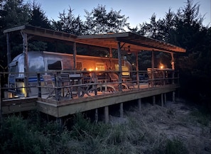Eine rustikale Holzdielen-Terrasse mit überdachter Sitzecke und einem Wohnmobil.