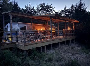 Eine rustikale Holzdielen-Terrasse mit überdachter Sitzecke und einem Wohnmobil.