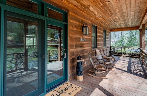A wooden cabin with a porch, sliding glass doors, outdoor seating, and a welcome mat. - Secluded Family Retreat in Log Cabin with Hammock and Fire Pit in Topton, North Carolina (Topton)