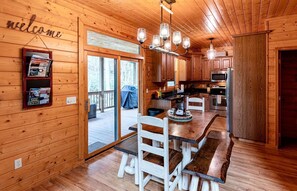 A wooden cabin interior with a dining area, kitchen, and a welcome sign. - Secluded Family Retreat in Log Cabin with Hammock and Fire Pit in Topton, North Carolina (Topton)