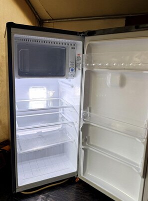 An open refrigerator with multiple shelves and a control panel.