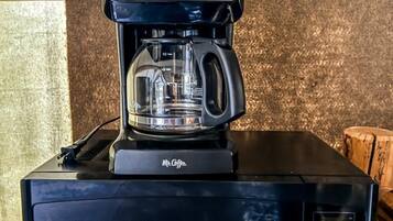 A black Contour microwave with a McCafé coffee maker on top.