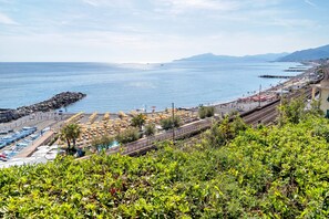 A coastal view with a beach, a train track, and a rocky breakwater. - Terrace by the Sea Apartment with Sea View, Terrace, and Scenic Trails (Lavagna)