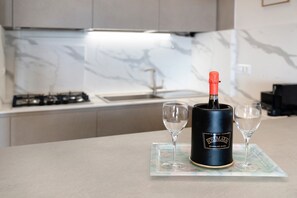 A kitchen with a marble backsplash, a gas stove, and a wine bottle on a tray. - Terrace by the Sea Apartment with Sea View, Terrace, and Scenic Trails (Lavagna)