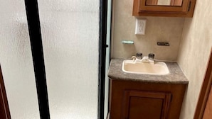 Un baño pequeño con inodoro, lavabo y ventana.