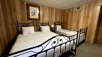 Une chambre avec un grand lit, un lit plus petit et une table de chevet.