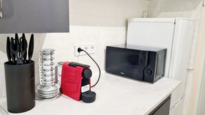 Une cuisine équipée d’un four à micro-ondes, d’un appareil électroménager rouge et d’ustensiles de cuisine.
