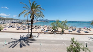 Ein Strand mit Palmen, Sonnenschirmen und Liegestühlen.