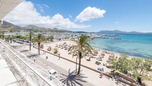 Un paysage urbain côtier avec une plage, des palmiers et un ciel bleu dégagé.
