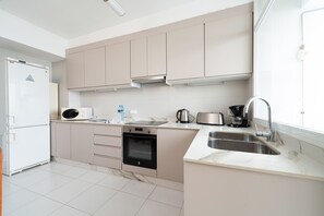 A modern kitchen with a built-in oven, microwave, and stainless steel sink. - Port de Pollença Esmeralda 3 (Port de Pollença)