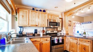 A kitchen with wooden cabinets, stainless steel appliances, and a granite countertop. - Farmhouse Retreat on 75 Acres with Fiber Wi-Fi, Near DeSoto (Mentone)