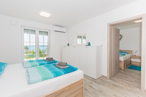 Ein Schlafzimmer mit zwei Betten, einem Kleiderschrank, einem Badezimmer und Meerblick.