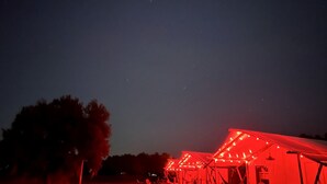 Una serie de estructuras con iluminación roja, posiblemente un evento o exposición temporal, frente a un cielo nocturno.