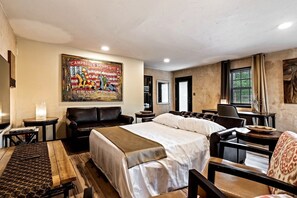 Une chambre d’hôtel avec un lit, un canapé, un bureau et un tableau au mur.
