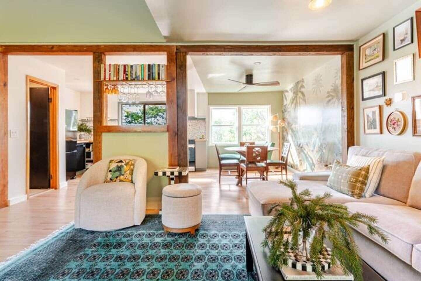 A spacious living room with a sofa, ottoman, and a dining area with chairs and a table.