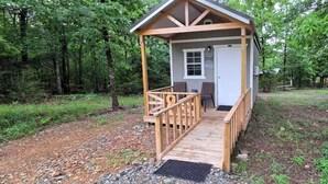 A small wooden cabin with a porch, surrounded by trees. - Peaceful Cabin Surrounded by Natural Beauty in Mena, Arkansas (Mena)