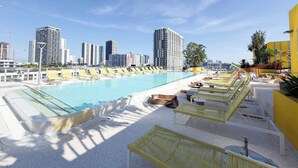 A rooftop pool with sun loungers and a city skyline in the background. - Heart of Brickell - Near Downtown (Miami)