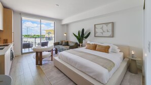 A modern hotel room with a large bed, a balcony with a view, a dining area, and a living space. - Heart of Brickell - Near Downtown (Miami)