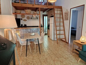 A kitchen with a wooden table and chairs, a refrigerator, and a ladder. - "Maritim"@MARISOL: 50m to the beach, private pool, A/C, WiFi, dog beach (Riumar)