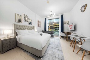 Ein modernes Schlafzimmer mit einem großen Bett, Nachttischen, einem Schreibtisch und einer Essecke.