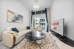 Ein modernes Wohnzimmer mit einer Couch, einem Couchtisch, einem Fernseher und einem Schild mit der Aufschrift 'BOOK ME'.