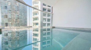 Ein modernes Gebäude mit Glasfassade und einem spiegelnden Pool.