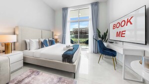 Ein modernes Hotelzimmer mit einem großen Bett, einem Schreibtisch, einem Fernseher und Blick ins Freie.