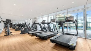 Ein modernes Fitnessstudio mit mehreren Laufbändern, Crosstrainern und Kraftgeräten.