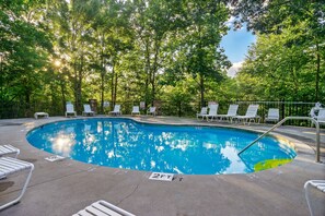 A swimming pool with lounge chairs and a fenced area, surrounded by trees. - Panoramic Views Cabin/ HotTub/ Arcade/ Ski/ Pickleball/ Golf in Gatlinburg,TN (Gatlinburg)