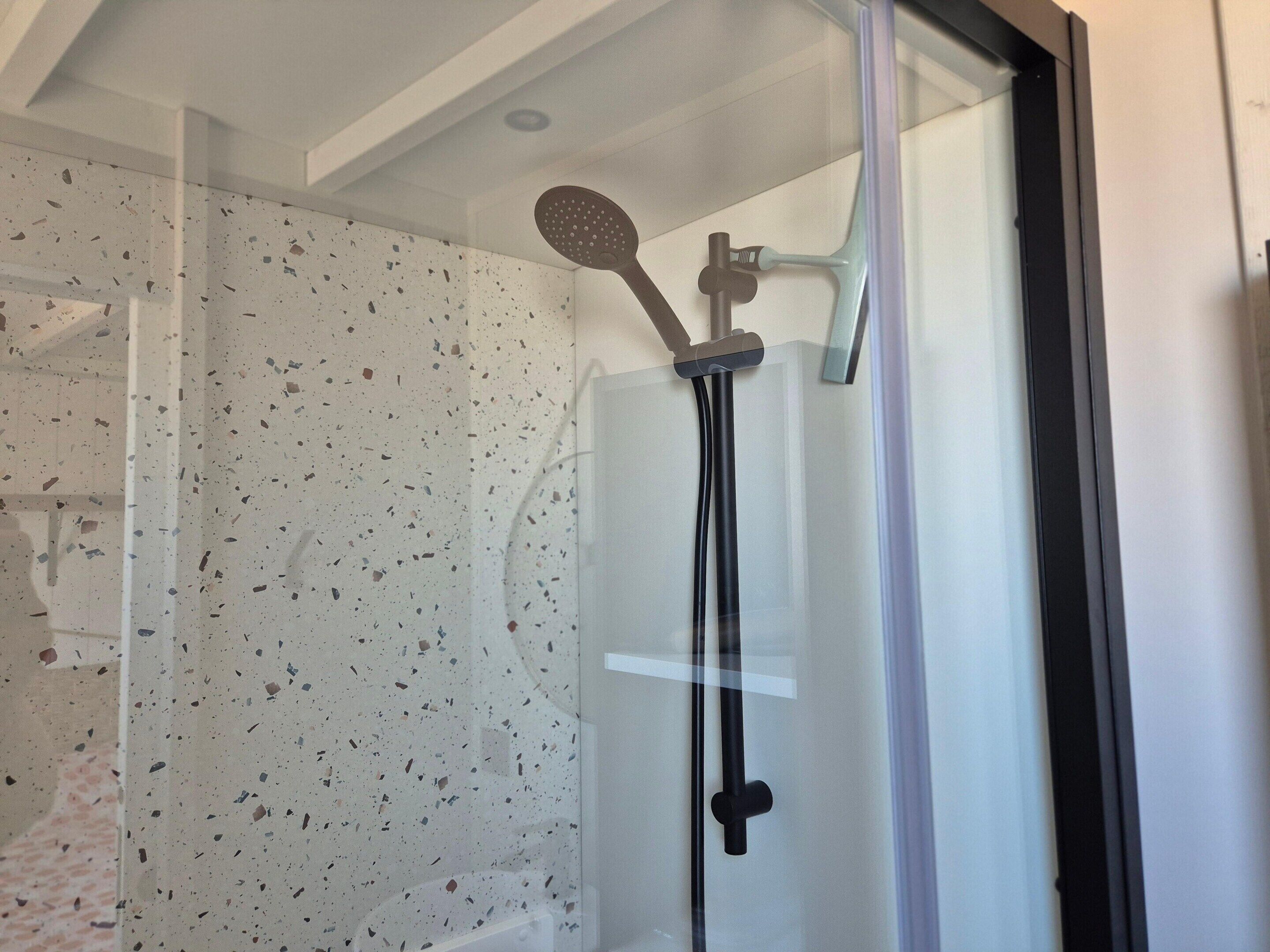 Eine Dusche mit Handbrause und Regendusche.