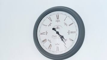 A wall-mounted clock with Roman numerals and decorative elements.