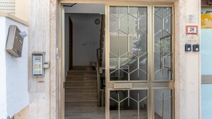 A building entrance with a staircase leading inside, a mailbox, and a door with a geometric pattern. - Allegra House - Three-Bedroom Apartment (Alba Adriatica)