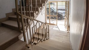 A staircase with wooden steps and metal railings leading to a glass door. - Allegra House - Three-Bedroom Apartment (Alba Adriatica)