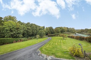 A curving road leading to a property surrounded by well-maintained lawns and dense trees. - 5 Bed in Garth (oc-c44957) (Treflys)