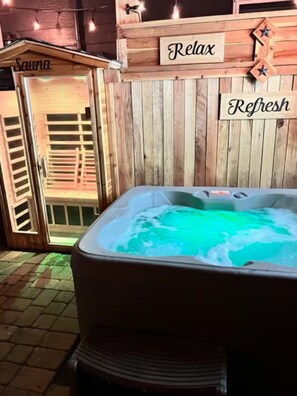 A hot tub with a wooden wall and two signs reading 'Relax' and 'Refresh.' - Tahoe Studio Spa Hot Tub+Sauna 1.5 Miles 2 Airport (Reno)