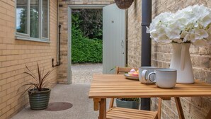 A wooden table with two mugs, a white vase with white flowers, and a potted plant. - 1 Bed in Great Ayton (oc-h44914) (Great Ayton)