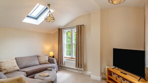A living room with a sofa, TV, and a window with curtains. - 1 Bed in Great Ayton (oc-h44914) (Great Ayton)