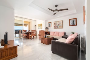 A spacious living area with a sofa, a coffee table, and a dining table with chairs. - Port de Pollen a Esmeralda 3 (Pollença)