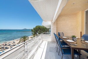 A balcony with a view of the sea, a dining table set with plates and glasses, and a chair. - Port de Pollen a Esmeralda 3 (Pollença)