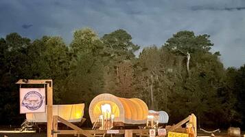 A rustic campground with wooden structures and a sign indicating a camping area.