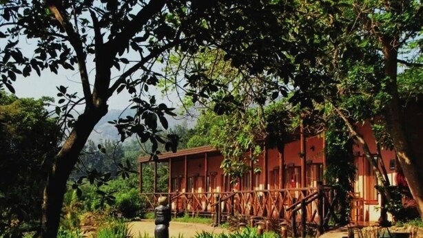A rustic building with a porch, surrounded by lush greenery. - Mvubu Falls Lodge (Lobamba)