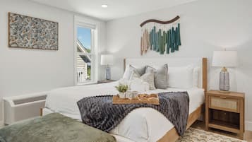 A bedroom with a bed, bedside tables, a wall-mounted macrame piece, and a window.